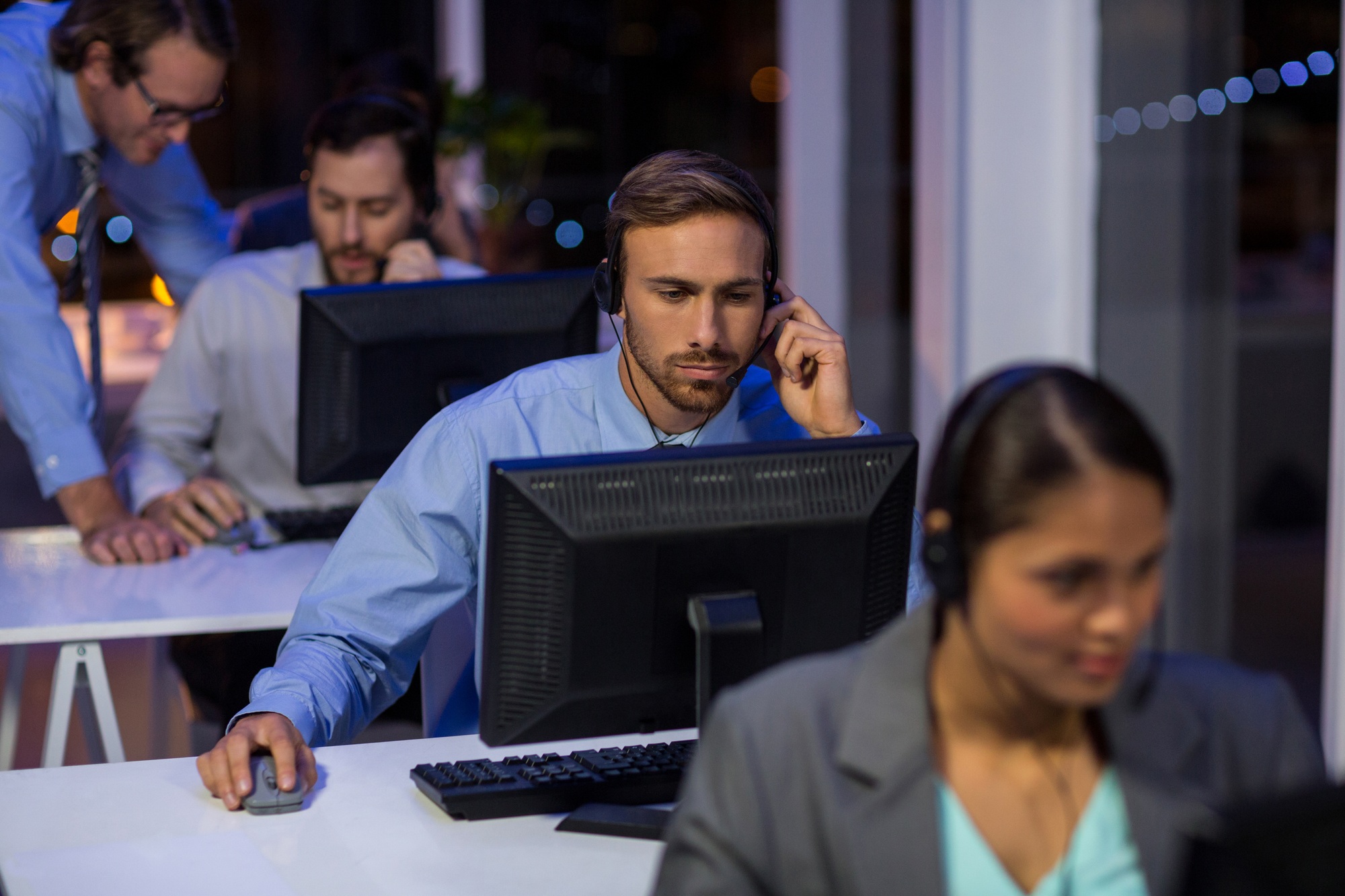 Businessman with headsets using computer in office